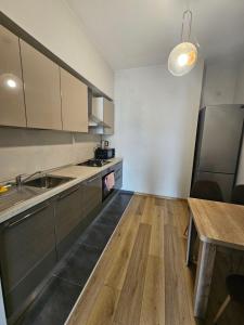 cocina con electrodomésticos de acero inoxidable y mesa de madera en Tbilisi Apartments -M2- complex Saburtalo en Tiflis