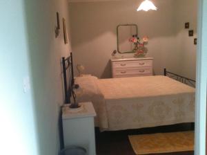 um quarto com uma cama e uma cómoda com um espelho em S'apposentu em Aritzo