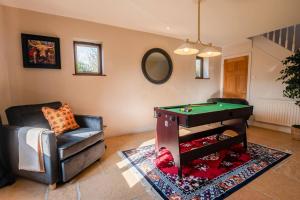 a living room with a pool table and a chair at Tree Tops House in Cheltenham