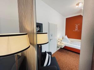 Habitación de hotel con 1 cama y 2 lámparas en Gästehaus Schmidt en Bad Lippspringe