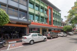 un grupo de coches estacionados frente a un edificio en Capital O 89344 Labuan Avenue Hotel, en Labuan