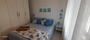 a small bedroom with a bed with blue pillows at Casa Mugnai in Piombino