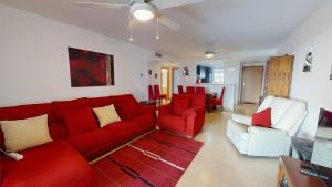 a living room with a red couch and white chairs at Casa Espliego PJ-Murcia Holiday Rentals Property in Torre-Pacheco