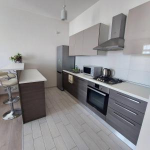 cocina con fregadero y fogones horno superior en Tbilisi Apartments -M2- complex Saburtalo en Tiflis
