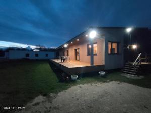 een klein huis met een terras 's nachts bij Maison calme à la campagne 