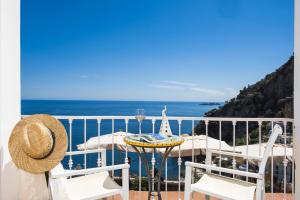 a balcony with a table and chairs and the ocean at Hotel Villa Gabrisa in Positano