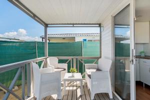 a balcony with white chairs and a table at Linda casita in El Palmar