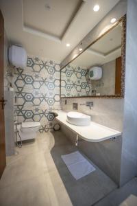 a bathroom with a sink and a toilet and a mirror at ASHOK VILLA in Jaipur