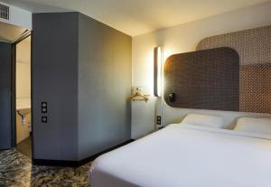 マルセイユにあるB&B HOTEL Marseille Parc Chanotのベッドとバスルーム付きのホテルルームです。