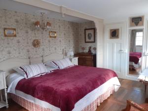 a bedroom with a large bed with a red blanket at Aux temps d'avant in Gundershoffen