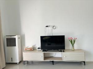 a tv sitting on top of a wooden entertainment center at บ้านม่วนใจ๋สันกำแพง in San Kamphaeng