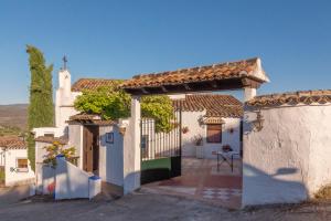 una casa bianca con cancello e cortile di Preciosa casa rural boutique con piscina privada, wifi a Zagrilla