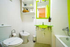 een badkamer met een toilet, een wastafel en een spiegel bij Acogedor y coquetísimo apartamento de diseño muy, muy, muy Centrico in Sevilla +11 foto's