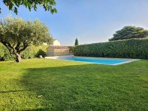 een zwembad in een tuin met een boom bij Villa Leis Moelos in Beaumes-de-Venise