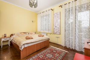 Camelia & Martina apartments في أوباتيا: غرفة نوم بسرير ونافذة كبيرة