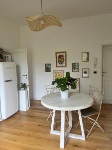 stół i krzesła w kuchni z białą lodówką w obiekcie Bloom as you are w Bolonii