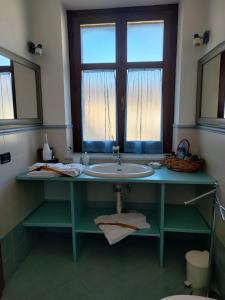 een badkamer met een wastafel en een raam bij Al Calar Della Sera in Sommariva del Bosco