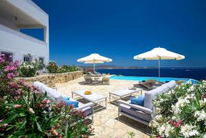 un patio con sillas y sombrillas y una piscina en Villa Sophia Patmos, en Patmos