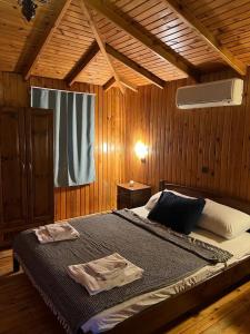 ein Schlafzimmer mit einem großen Bett in einem Holzzimmer in der Unterkunft Olympos Çınar Hotel in Olympos
