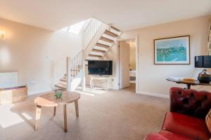 uma sala de estar com um sofá vermelho e escadas em Tree Tops House & Garden Cottage em Cheltenham