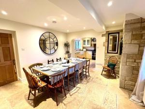 uma grande sala de jantar com mesa e cadeiras em Tree Tops House & Garden Cottage em Cheltenham