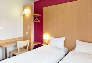 um quarto de hotel com duas camas e uma secretária em B&B HOTEL Paris Italie Porte de Choisy em Ivry-sur-Seine