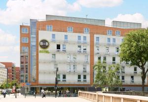 een groot gebouw met een bord aan de zijkant bij B&B HOTEL Paris Italie Porte de Choisy in Ivry-sur-Seine