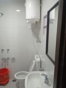La salle de bains est pourvue de toilettes, d'un lavabo et d'un miroir. dans l'établissement Pinez Guest House , Anantnag, à Anantnāg