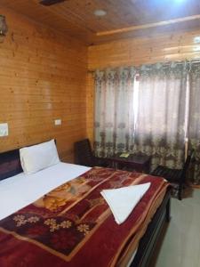 - une chambre avec un lit et une fenêtre avec des rideaux dans l'établissement Pinez Guest House , Anantnag, à Anantnāg