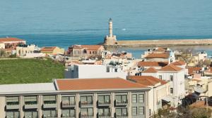 a view of a city with a lighthouse in the background at The Chania Hotel in Chania Town