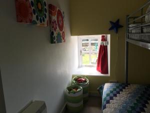 a bedroom with a bed and a window and a crib at The Steps Llandeloy in Llandeloy