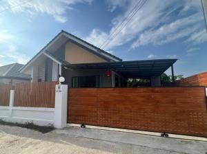a house with a wooden fence in front of it at บ้านม่วนใจ๋สันกำแพง in San Kamphaeng