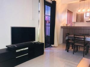 a living room with a television and a dining room at Salty Bisous in Pointe aux Sable