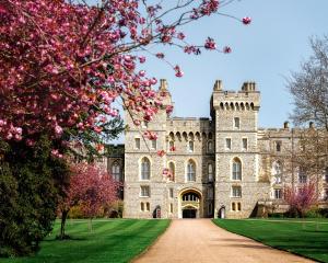 un castello con fiori rosa di fronte di Central Windsor Spacious Three Double BedRooms, Two Living Room, Kitchen Entire Apartment over three floors Steps from Windsor Castle, station, long walk and restaurants Royal Residence Retreat Windsor a Windsor