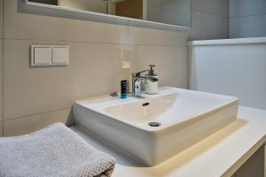 lavabo blanco en el baño con espejo en Haus Fünf en Melk