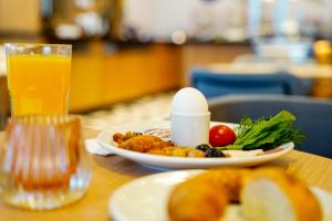 a table with a plate of food and a glass of orange juice at Holiday Inn Express - Ankara - Airport by IHG in Ankara