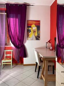 a dining room with purple curtains and a table at Draisina Bike ROOM in Oleggio Castello +9 photos