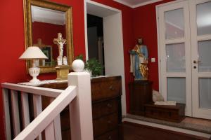 a hallway with red walls and a statue of a crucifix at The Blue House in Tolmin