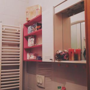 a kitchen with red shelves and a white cabinet at Pink Panter Doboj in Doboj