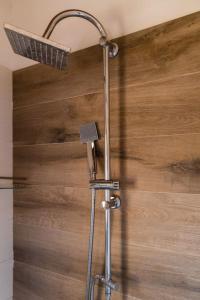 y baño con ducha y pared de madera. en Appartamento Porta Pispini, en Siena