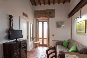 サン・ジミニャーノにあるAppartamento La Roccaのソファとテレビのあるリビングルーム