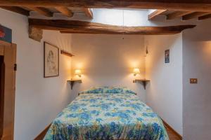 サン・ジミニャーノにあるAppartamento La Roccaのベッドと壁に2つのライトがある寝室