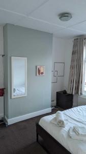 a white bedroom with a bed and a window at 3 bedroom house,4beds, 2 baths Ilford ,12 mins to Stratford in London