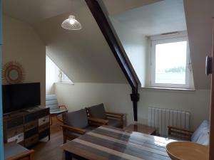 a living room with a dining room table and a window at Guingamp centre : grand appartement lumineux in Guingamp