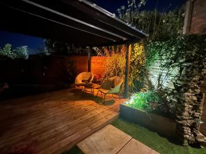 two chairs and a table on a deck at night at The Cottage Hideout in Upholland