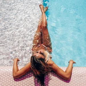 - une fille se posant au bord d'une piscine dans l'établissement Paradiso Ibiza Art Hotel - Adults Only, à Bahía de Sant Antoni