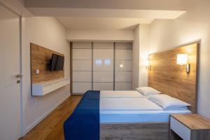 a bedroom with a bed and a tv on a wall at Apartments by BOR - BOR Hotel Complex in Zlatibor