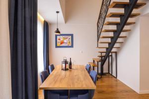 uma sala de jantar com uma mesa de madeira e cadeiras azuis em Apartments by BOR - BOR Hotel Complex em Zlatibor