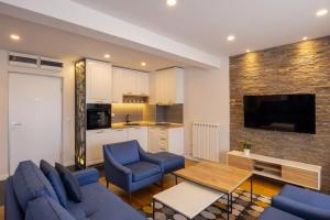 ein Wohnzimmer mit 2 blauen Stühlen und eine Küche in der Unterkunft Apartments by BOR - BOR Hotel Complex in Zlatibor