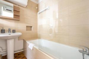a bathroom with a white tub and a sink at Comfortable flat - Montparnasse in Paris